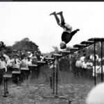 Alexander Patty balances on head and jumps up staircase