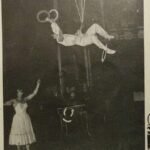 Angel Bojilov Sr laid down on slackwire spinning three plates on long sticks and juggling three rings