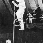 Angel Bojilov Sr standing on one foot on slackwire while performing a combination juggling trick
