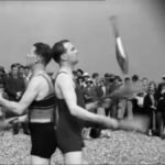 Eddy and Roy Van Wyck aka The Juggling Demons juggle clubs back to back on a beach