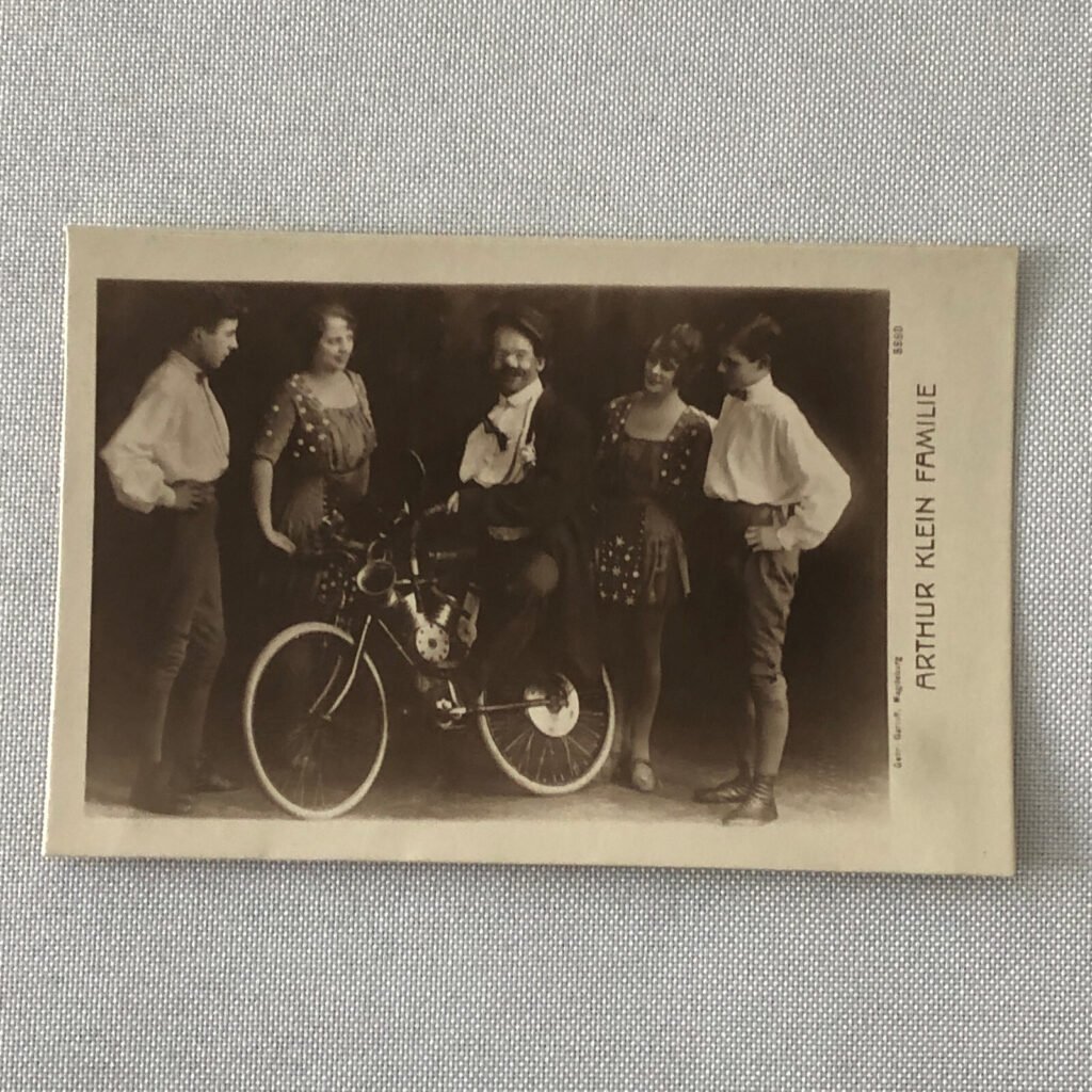 family photo of five people with man sitting on bicycle
